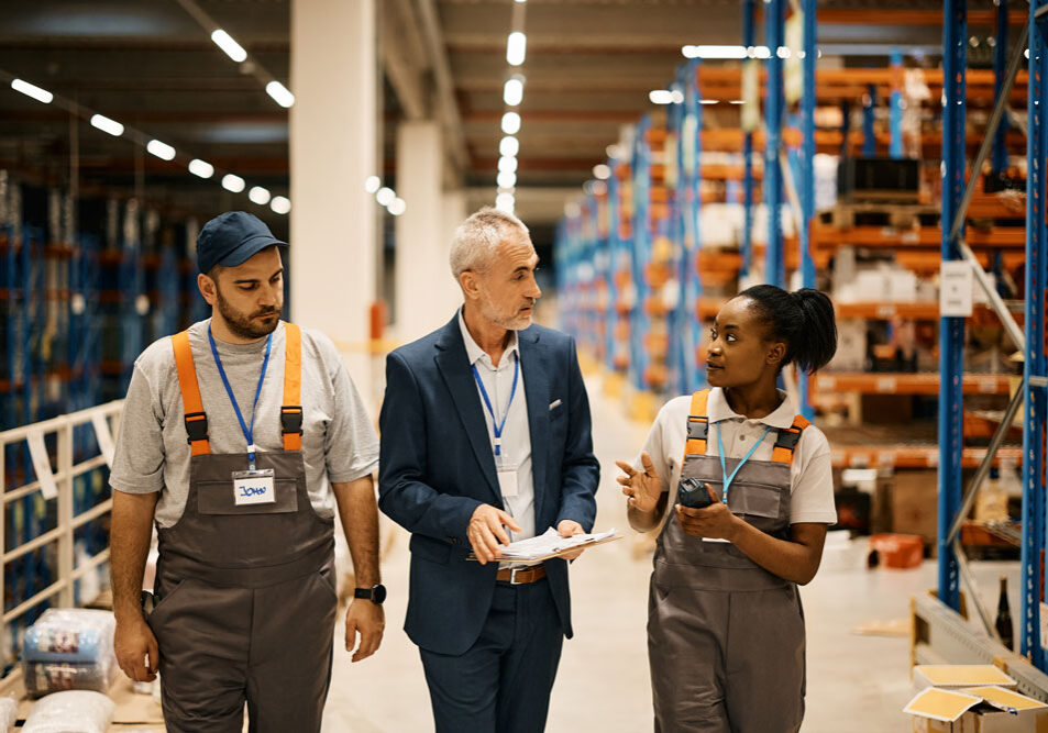 Three people walking through a warehouse